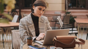 Mujer planificando un viaje internacional desde su laptop en una cafetería