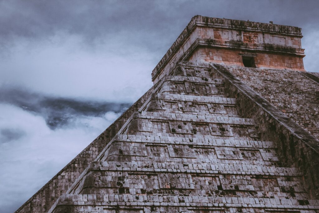 beautiful shot of the chichen itza with cloudy sky in the background